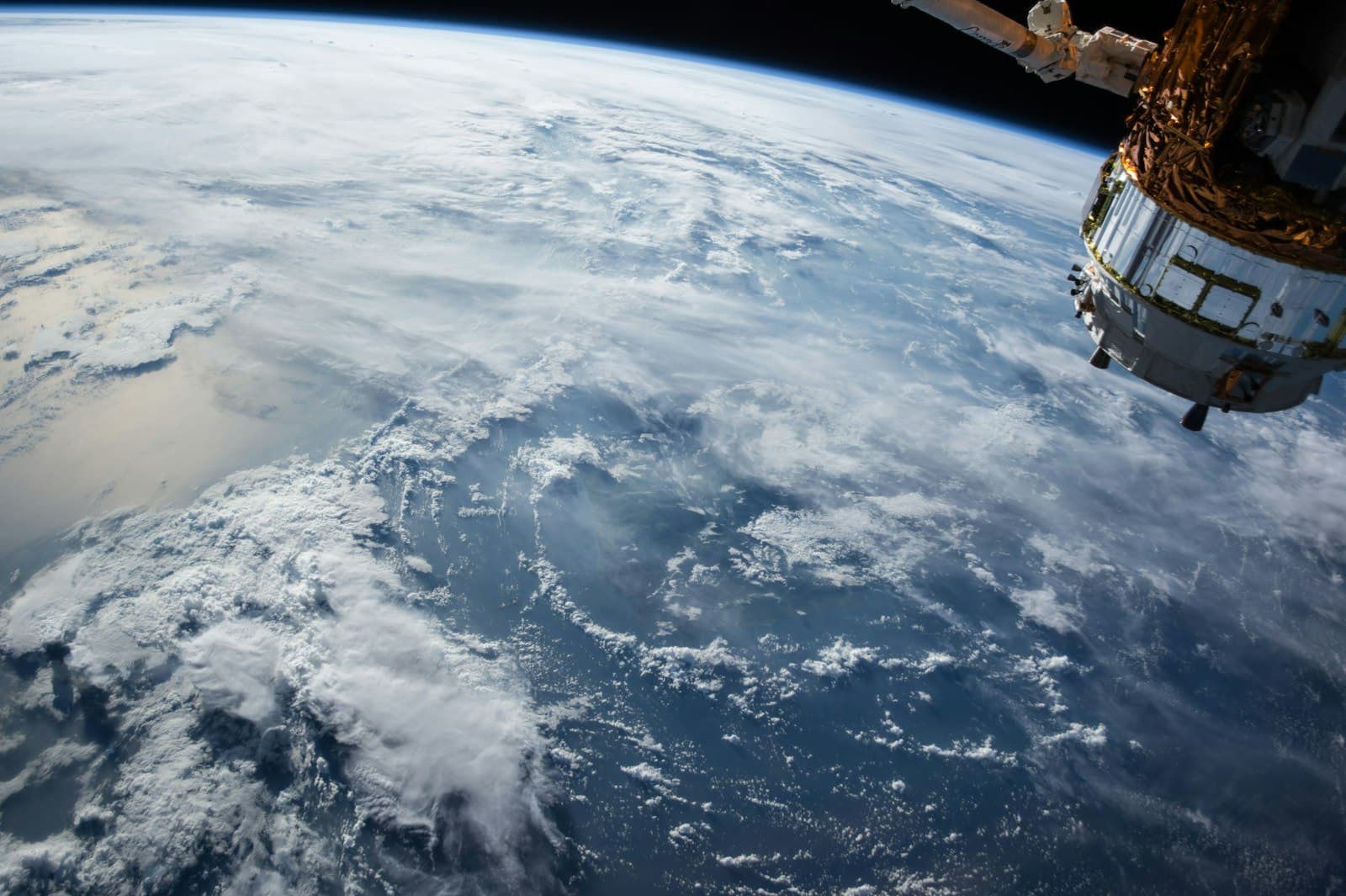 Earth seen from low orbit with spacecraft hardware in frame
